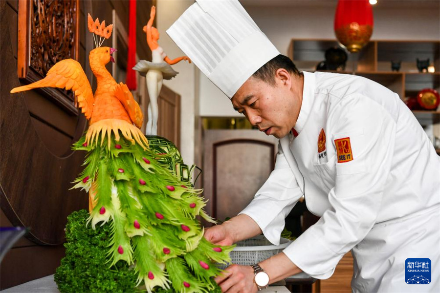 2月20日，厨师在俄罗斯莫斯科举行的“珍奇辽味”走进俄罗斯活动上制作“孔雀迎宾”食雕。新华社记者曹阳摄