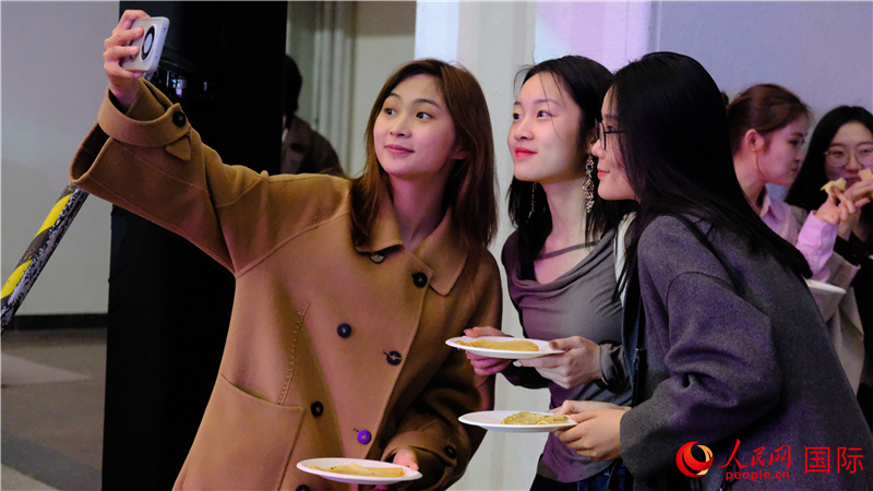 中国观众在现场品尝“谢肉节”节日美食——煎薄饼。人民网 褚梦琦摄