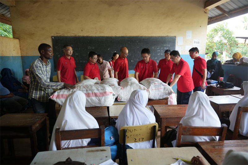 医疗队队员给东港中学的孤儿搬运捐赠的食品。中国援桑医疗队供图