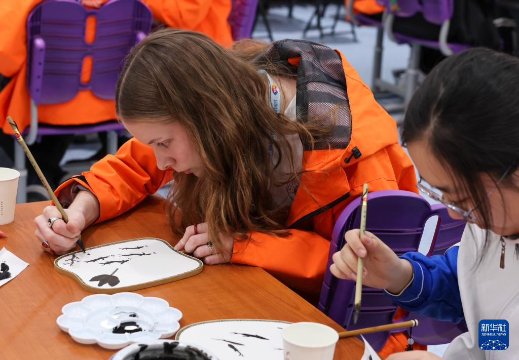 3月18日，在清华大学附属中学，美国华盛顿州中学生代表团的成员与中国中学生一起体验水墨画扇面绘制。新华社记者 殷刚 摄