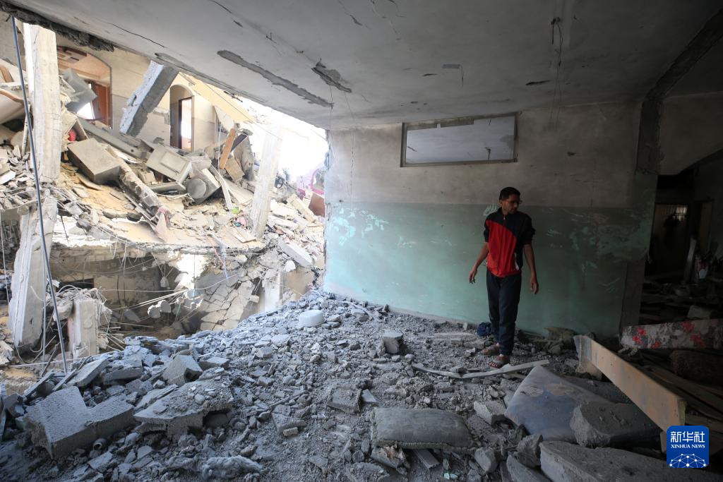 4月20日，在加沙地带南部城市拉法，巴勒斯坦人查看被以军空袭的建筑。新华社发（亚西尔・库迪摄）