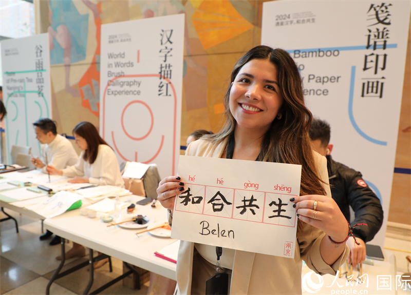 1、在活动上，嘉宾们体验汉字书法等文化活动，图为一名嘉宾展示自己书写的汉字书法。人民网记者 李志伟摄