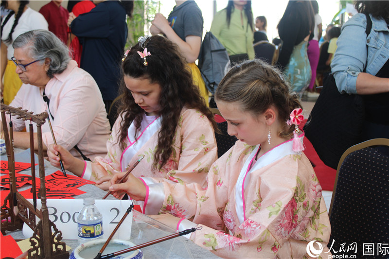 2、在活动上，美国学生拿起毛笔体验中国书法。 伊莎贝尔·罗德里格斯摄