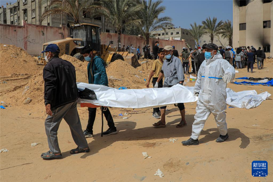 4月23日，工作人员在加沙地带南部城市汗尤尼斯的纳赛尔医疗中心转移尸体。新华社发（里泽克・阿卜杜勒贾瓦德摄）
