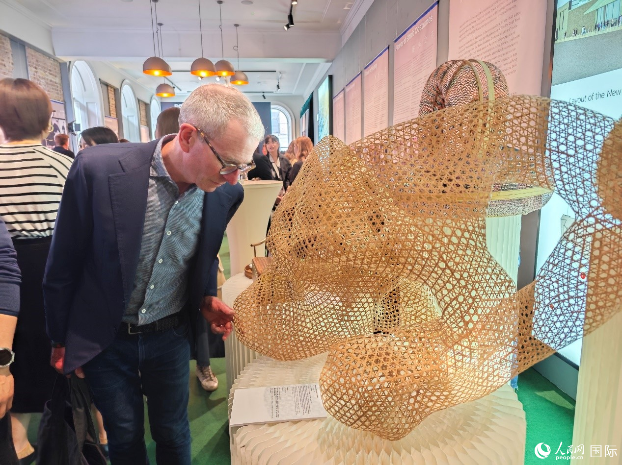 伦敦手工艺周主席盖伊·索尔特在认真欣赏竹编雕塑作品《石为云根》。动交人民网记者 邢雪摄