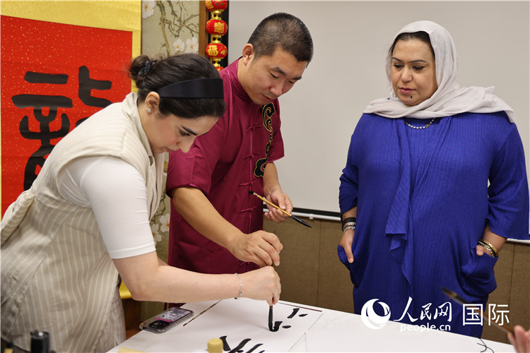 科威特公务员中文学习班上，中国书法老师指导学员练习中国书法，张志文摄