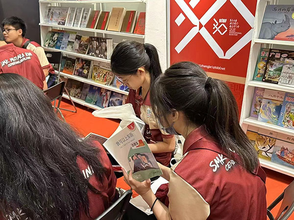 马来西亚读者在中国联合展台翻阅中国书籍。 中国图书进出口（集团）有限公司供图