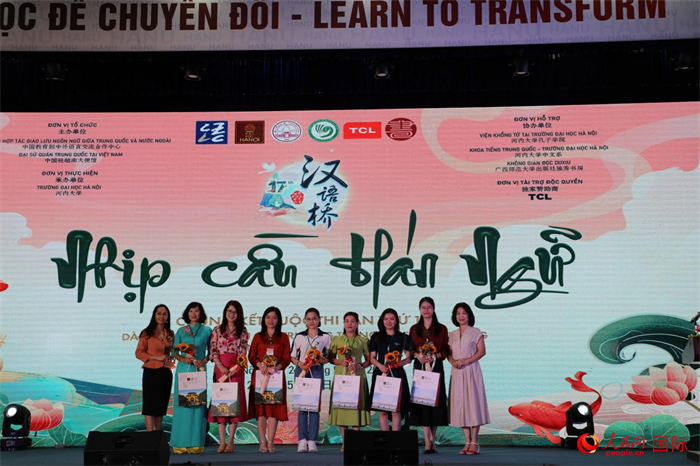 比赛现场，越方嘉宾为开展中文教育课程的越南高级中学代表献花。人民网记者 杨晔摄
