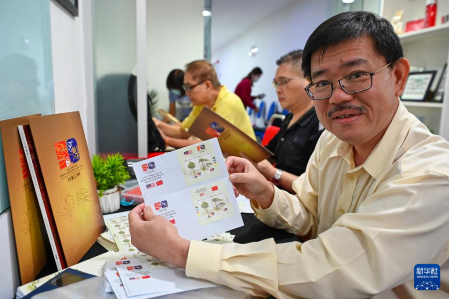5月31日，在马来西亚吉隆坡，顾客展示购买到的《中马建交五十周年》联合纪念邮票。新华社发（张纹综摄）