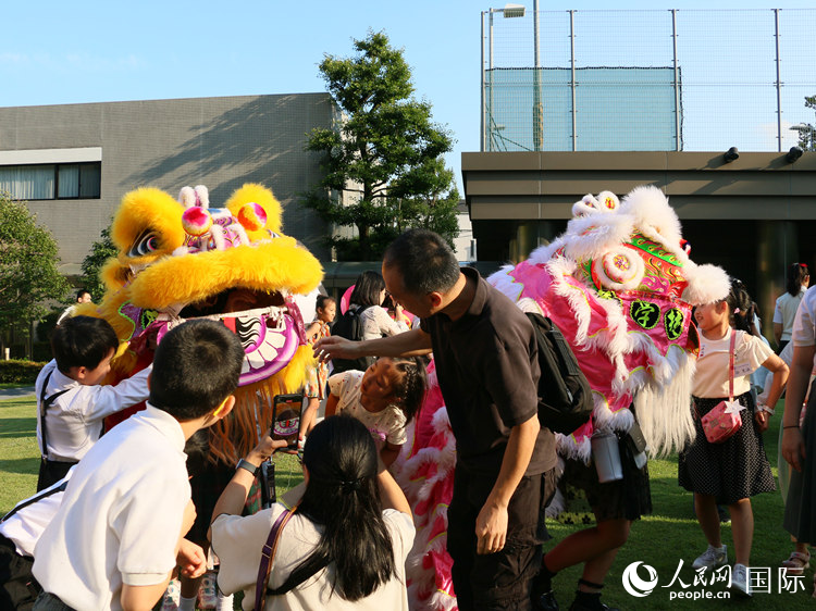 孩子们好奇地围观舞狮。人民网 许可摄