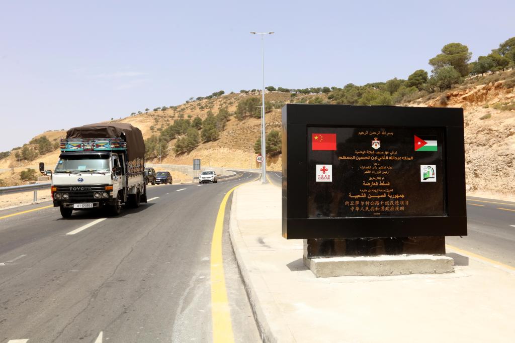 5月27日，在约旦萨尔特，车辆驶过萨尔特公路旁设立的中国援约旦萨尔特公路升级改造项目纪念碑。新华社发（穆罕默德·阿布·古什摄）