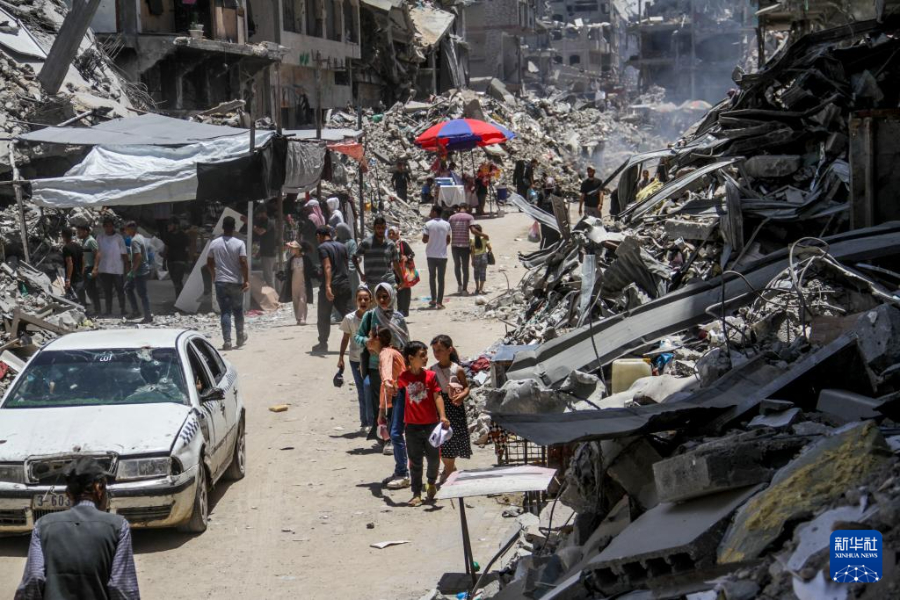 6月20日，在加沙地带北部杰巴利耶难民营，人们在建筑废墟间搭建了一处集市。新华社发（马哈茂德・扎基摄）