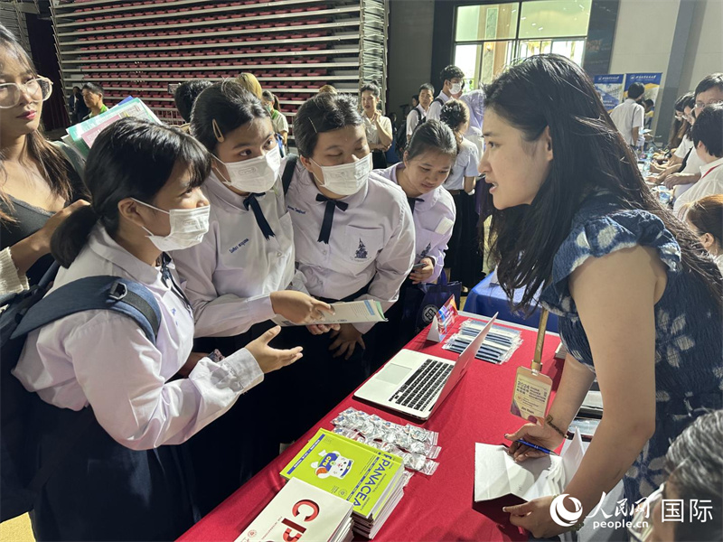 来自泰国的学生、家长在教育展台前咨询。人民网记者 简承渊摄