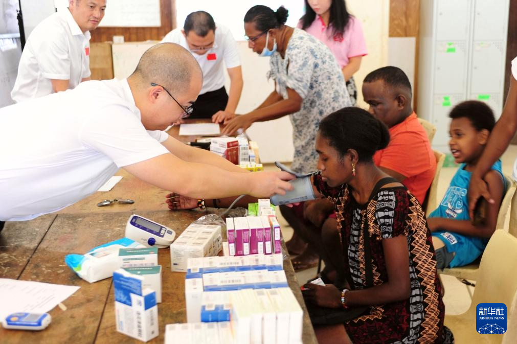 6月28日，在所罗门群岛霍尼亚拉，中国医疗队队员为当地民众看诊。新华社记者 章建华 摄