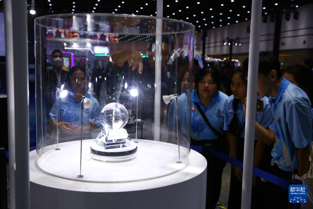 7月25日，學生們在泰國曼谷舉行的「2024泰國未來科學力量展覽會」上觀看展出的嫦娥五號月壤樣本。