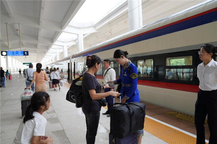 中老鐵路工作人員在站臺指引旅客進站乘車。老中鐵路有限公司供圖