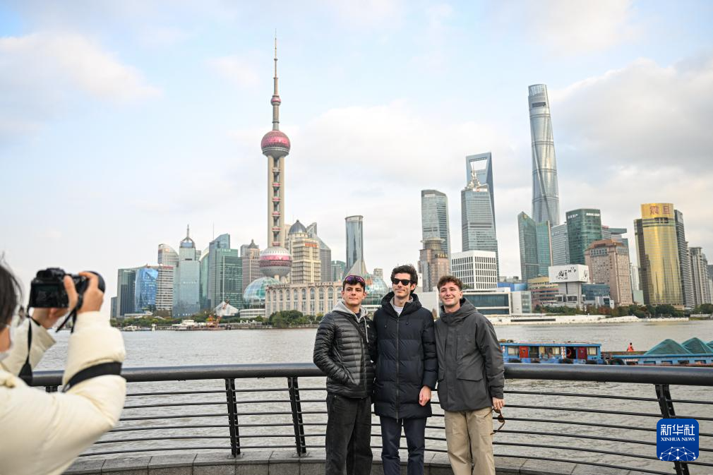 12月4日，来自西班牙的游客在上海外滩拍照留影。新华社发（陈浩明 摄）