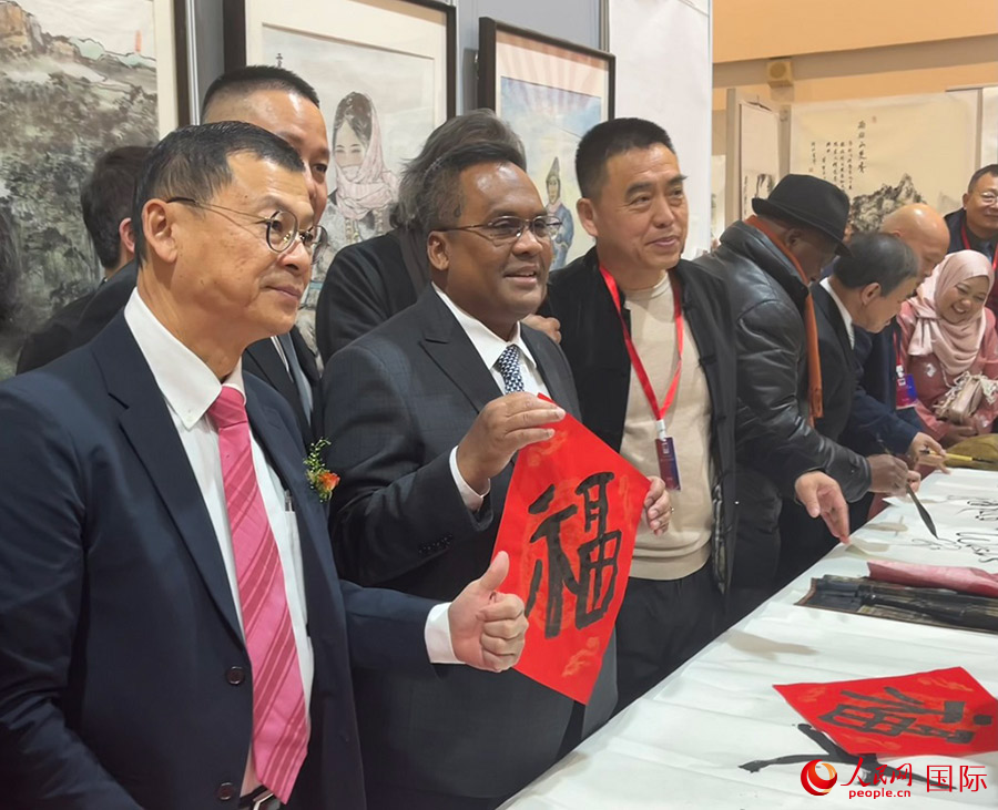 马来西亚驻华大使诺曼（中）展示其写的“福”字。人民网 喻亮摄