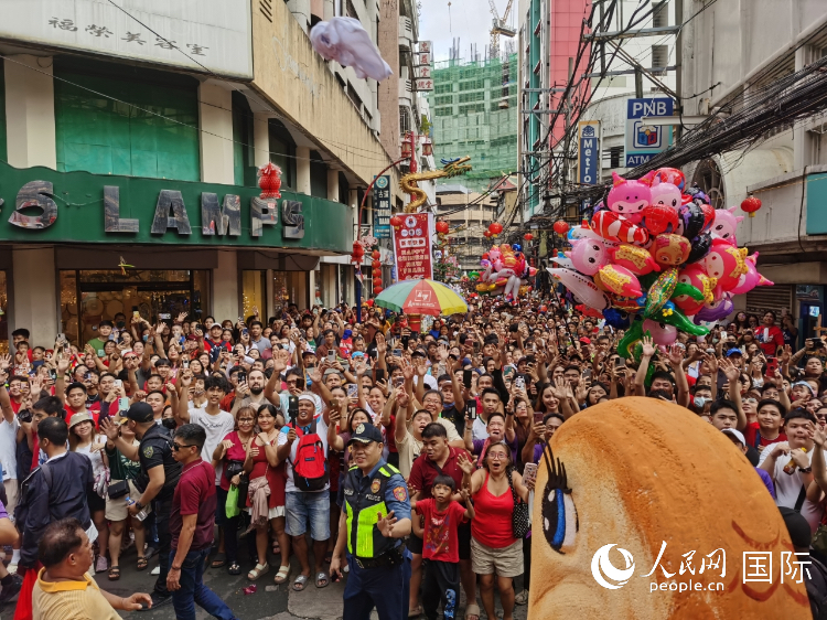 马尼拉市百万民众参与春节花车巡游活动，沿途民众与花车合影留念。人民网记者 樊帆摄