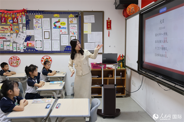 迪拜中国学校301班同学在老师的带领下，学习古诗《元日》。人民网记者 张志文摄