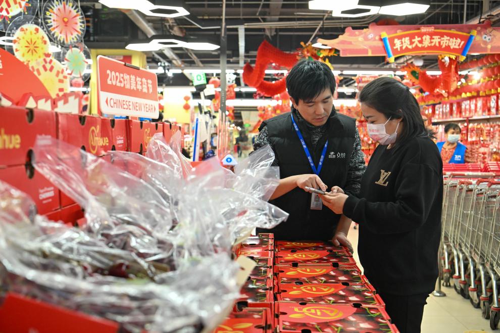 2024年12月26日，在天津市西青区一家大型商超，工作人员指导顾客线上下单智利车厘子。新华社记者孙凡越摄