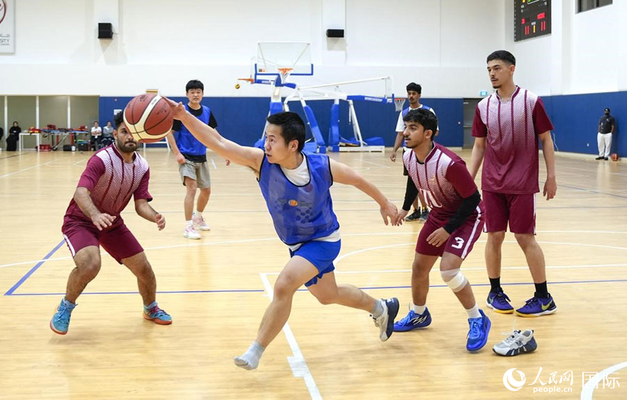 由中国留学生组成的阿联酋人工智能大学篮球队（蓝衣）在比赛中。人民网 塔里克·易卜拉欣摄