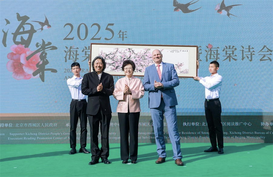 中国宋庆龄基金会主席李斌（中）与瑞士驻华大使白瑞谊（右二）一起，为画家丁杰（左二）创作的国画《盛世海棠》点上花蕊，并宣布活动开幕。   中国宋庆龄基金会供图