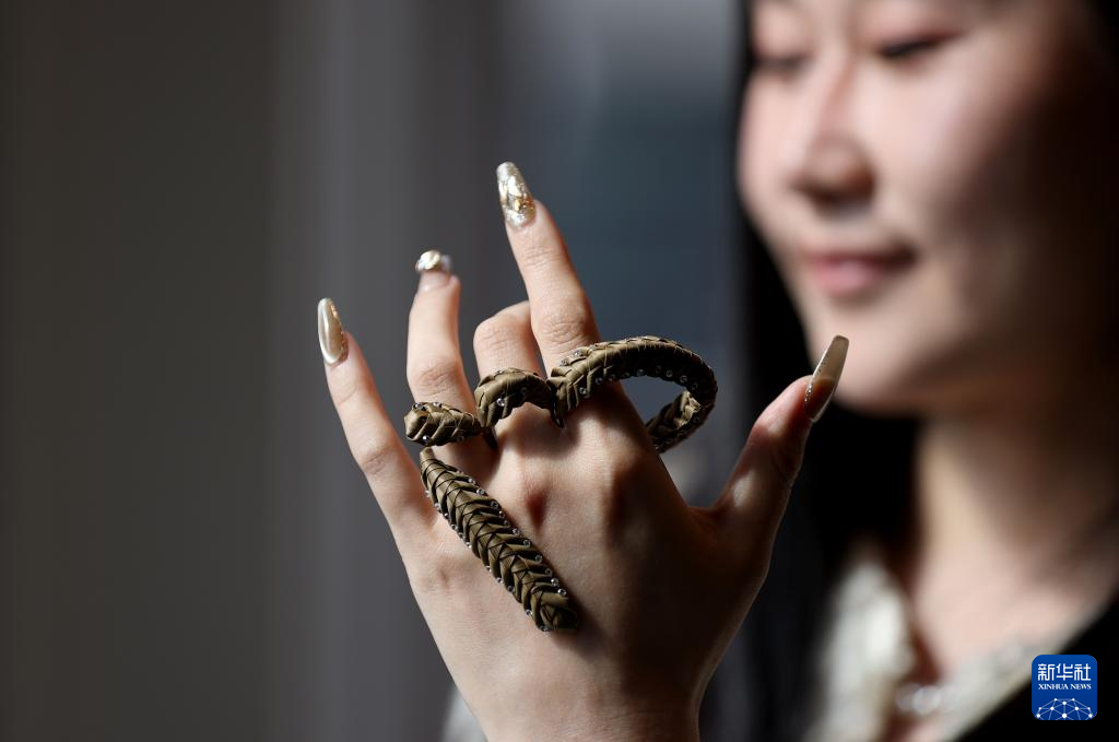 5月12日，在英国伦敦举行的伦敦工艺周中国国家馆开幕活动上，一名女子展示棕编工艺品。新华社记者 李颖 摄