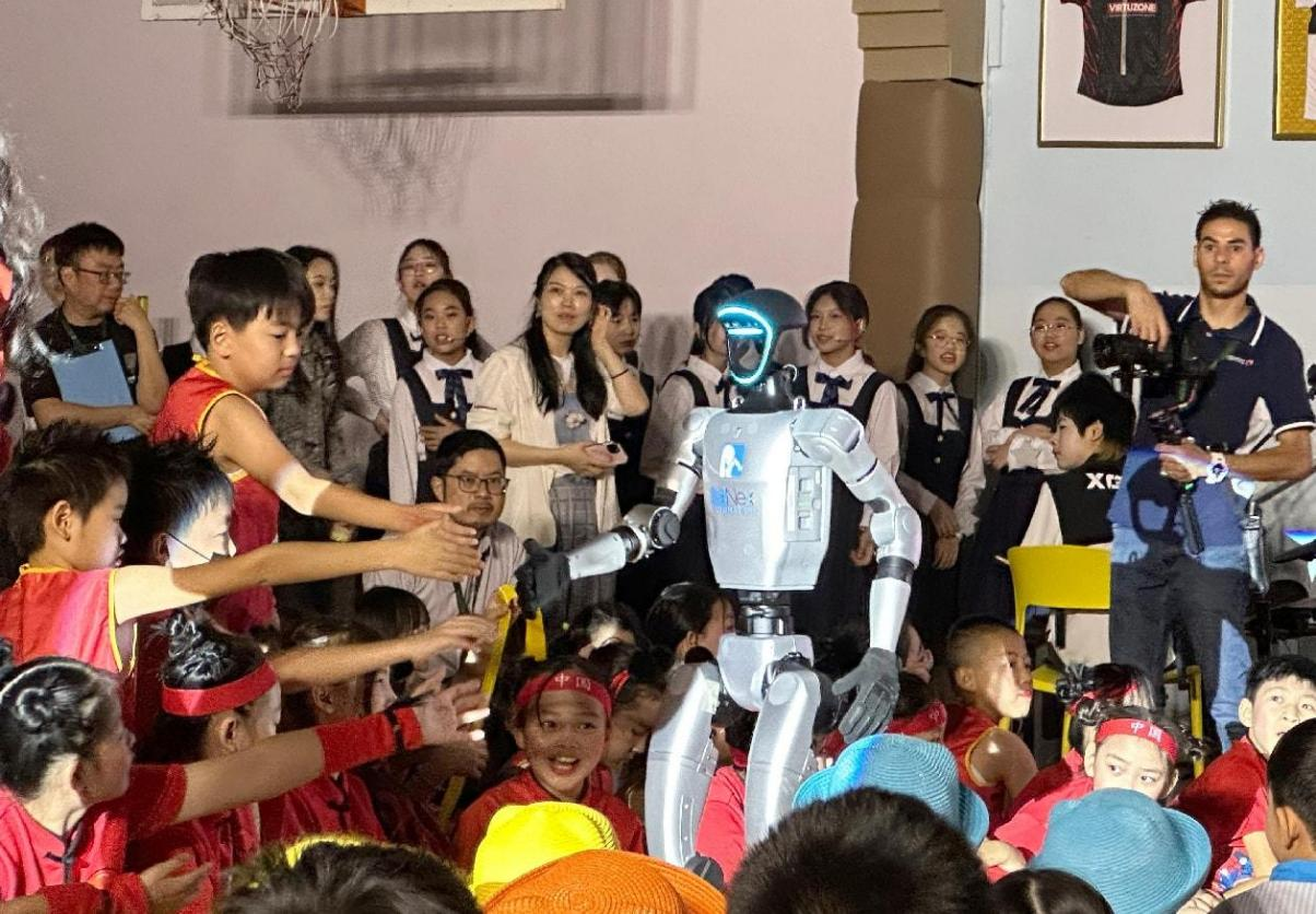孩子们争相同机器人握手。迪拜中国学校供图