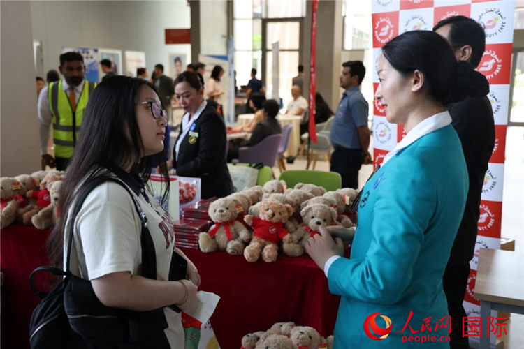 招聘会上，求职者在一家当地企业展台咨询。人民网记者 张志文摄