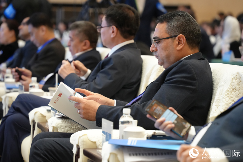 与会嘉宾翻看报告。人民网记者章凯风摄