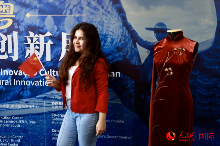 主题展览和文化体验活动现场，一名手持中国国旗的里约市民与中国传统服饰合影留念。人民网记者宋亦然摄