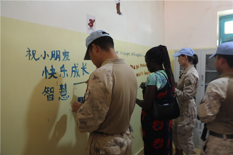 图为维和官兵在留言墙写祝福语。张晓昆摄