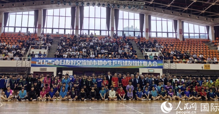 出席2025中日友好交流城市初中生乒乓球友谊比赛大会开幕式的嘉宾与参赛选手等合影留念。人民网记者 陈建军摄