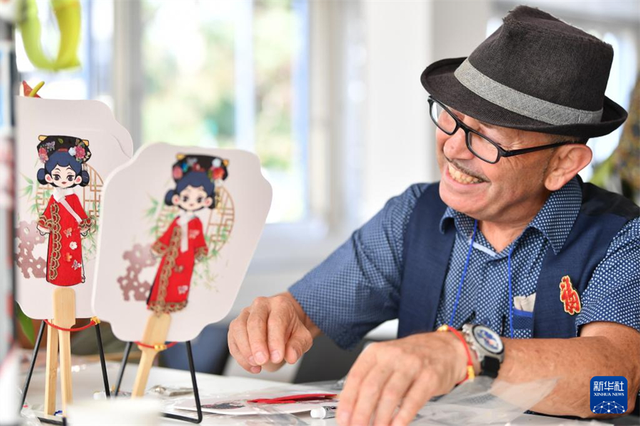 8月22日，在瑞士伯尔尼中国文化中心，嘉宾在 “安善萃锦——中式生活美学展”开幕式上体验制作扇子。新华社记者 连漪 摄