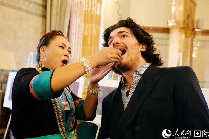 英国嘉宾在推介会现场体验贵州侗族敬酒仪式。杨浩鹏摄