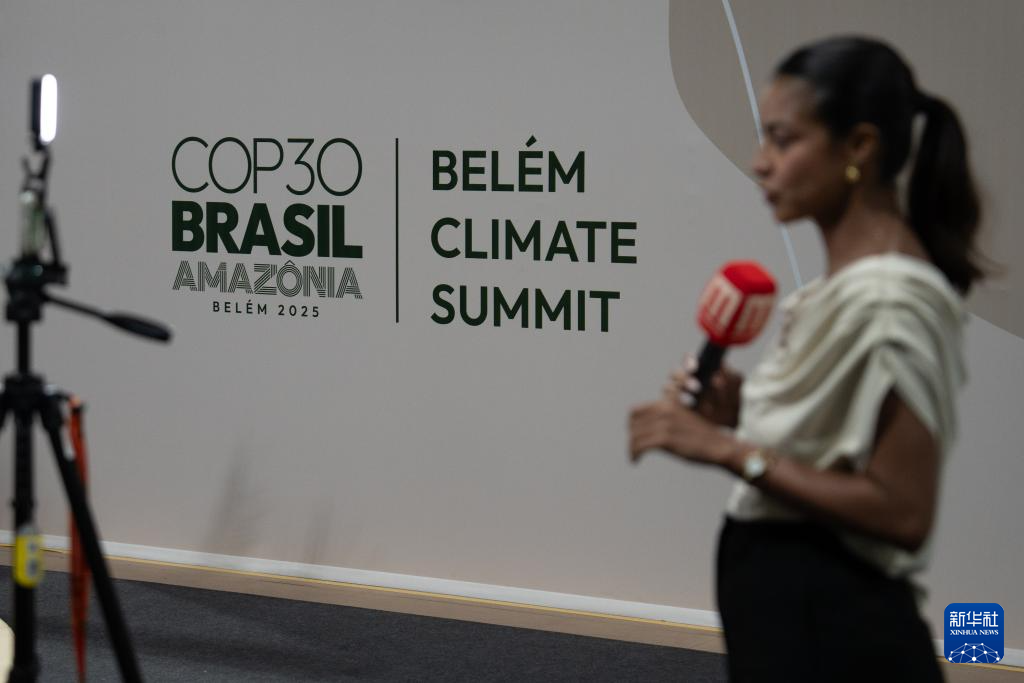 11月6日，在巴西贝伦，一名记者在《联合国气候变化框架公约》第30次缔约方大会贝伦气候峰会标识前出镜。新华社记者 王天聪 摄
