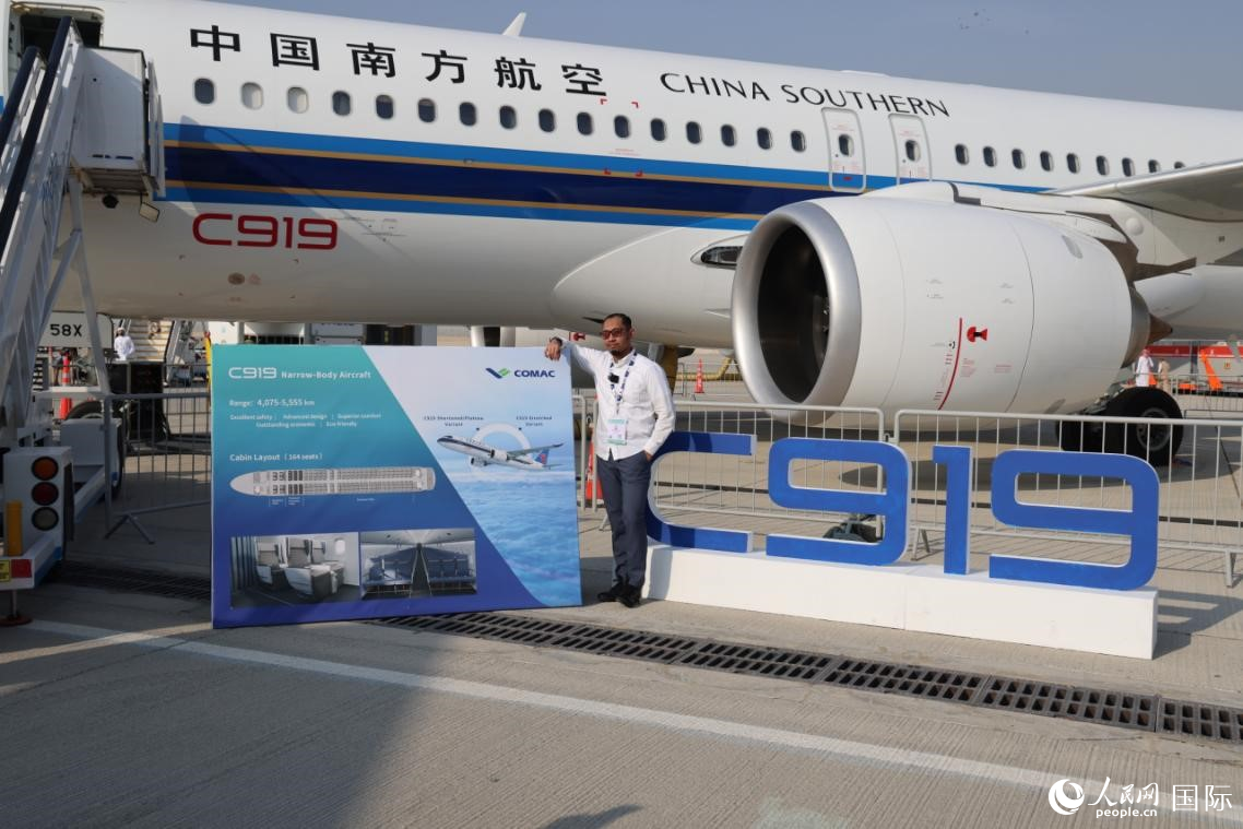 一位来自印尼的飞行员与南航C919合影。人民网记者 张志文摄