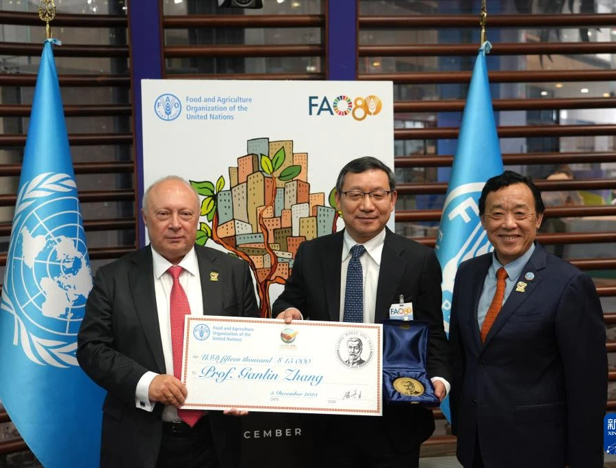 12月5日，在意大利首都罗马，联合国粮农组织总干事屈冬玉（右）向张甘霖（中）颁授2025年格林卡世界土壤奖奖牌。新华社记者 任耀庭 摄