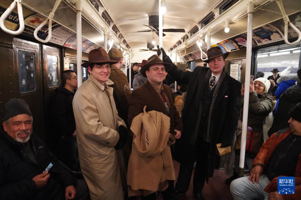 12月14日，在美国纽约，人们身着怀旧服饰乘坐“怀旧地铁”。新华社记者 张凤国 摄