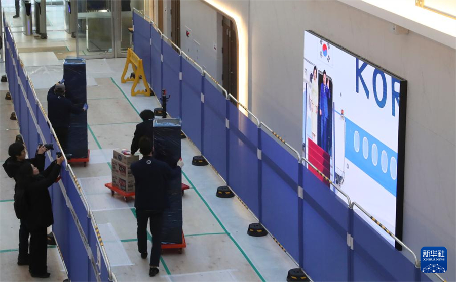 12月22日，在韩国首尔，工作人员在龙山总统府搬运办公用品。新华社记者 姚琪琳 摄