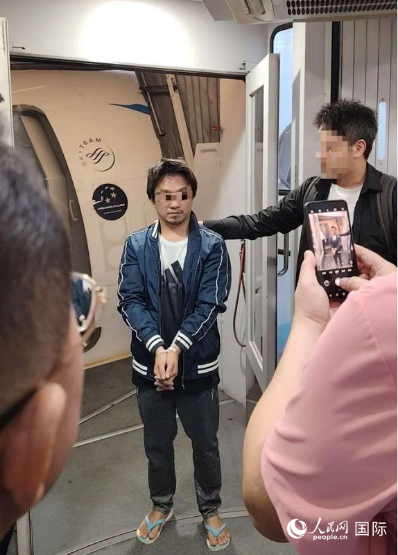 涉绑架杀害中国公民嫌疑人施纯芳22日下午被押解上飞机，遣返回国。人民网记者 樊帆摄