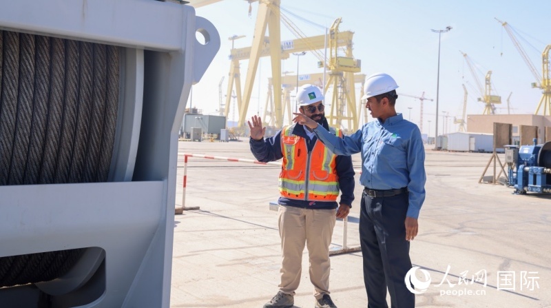 沙特阿美国王港项目经理马尔万·纳赛尔（右）在项目现场与同事交流。人民网记者任皓宇摄