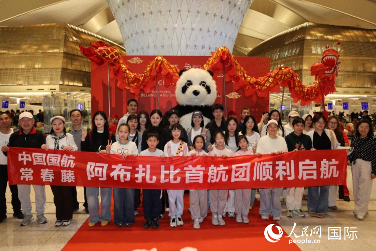 乘坐首航回国的旅行团在阿布扎比扎耶德国际机场内合影。人民网记者 张志文摄