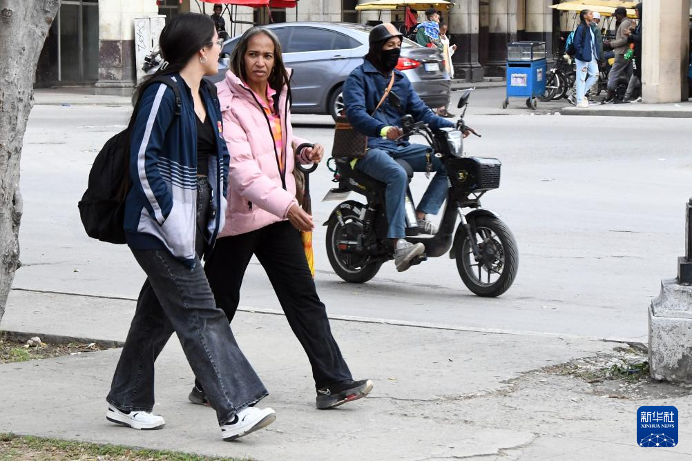 2月3日，在古巴首都哈瓦那，当地民众穿着长袖外套走在街头。