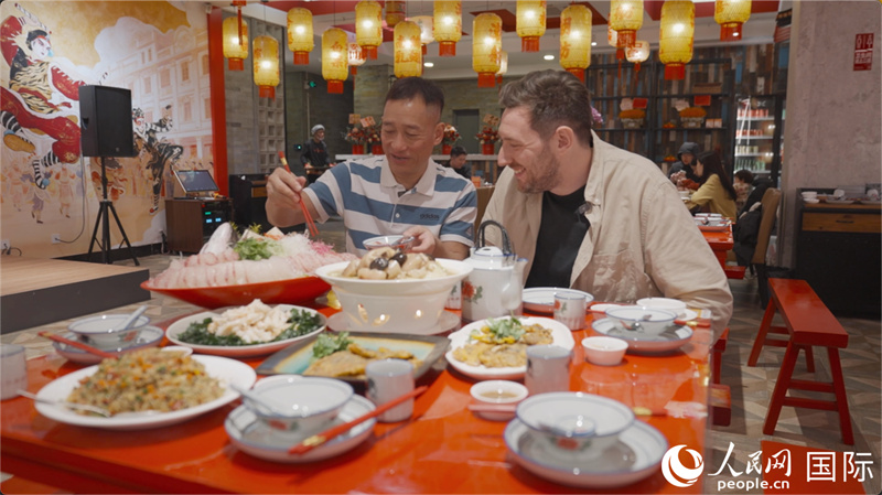 广东汕头，人民网外专柯明可与陈志毅师傅（左一）在潮舫英歌宴餐厅品尝他们制作的菜肴。人民网记者 刘宁摄