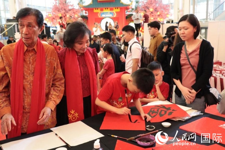 当地民众体验中国书法，现场书写“福”字。人民网记者 曹师韵摄