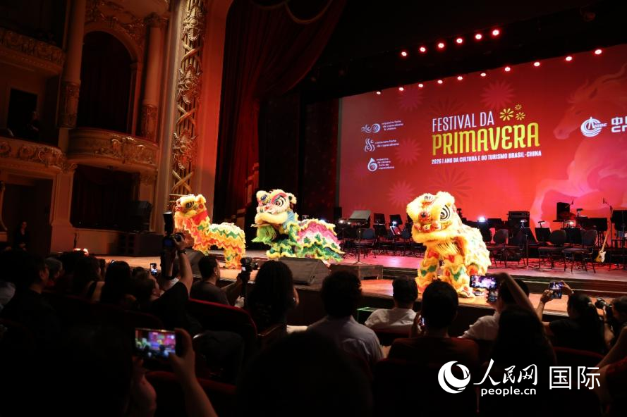 在巴西里约热内卢举行的2026年新春演出活动现场，舞狮表演引起观众争相拍照。人民网实习生 侯天泽摄