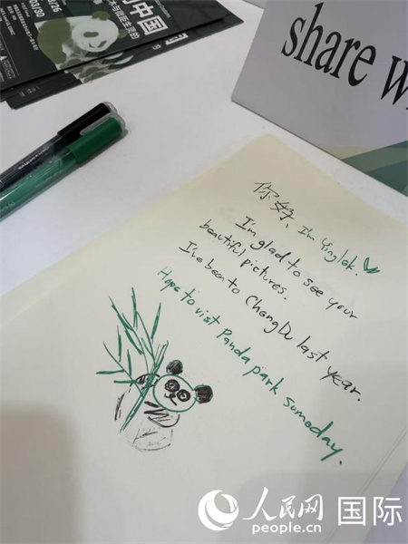 图片展现场的观众留言册上,海外民众积极评论打卡并画下了生动活泼的熊猫手绘。 人民网记者 张矜若摄