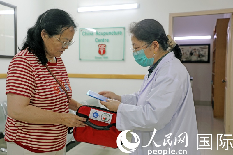 义诊期间,巴基斯坦岐黄中医中心的医生向在巴中国公民发放医疗急救包。人民网记者赵益普摄(1)